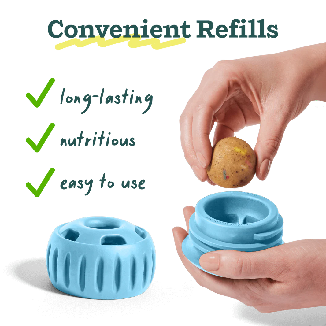 Blue Pupsicle toy dispenser with removable lid and a hand holding a brown treat ball
