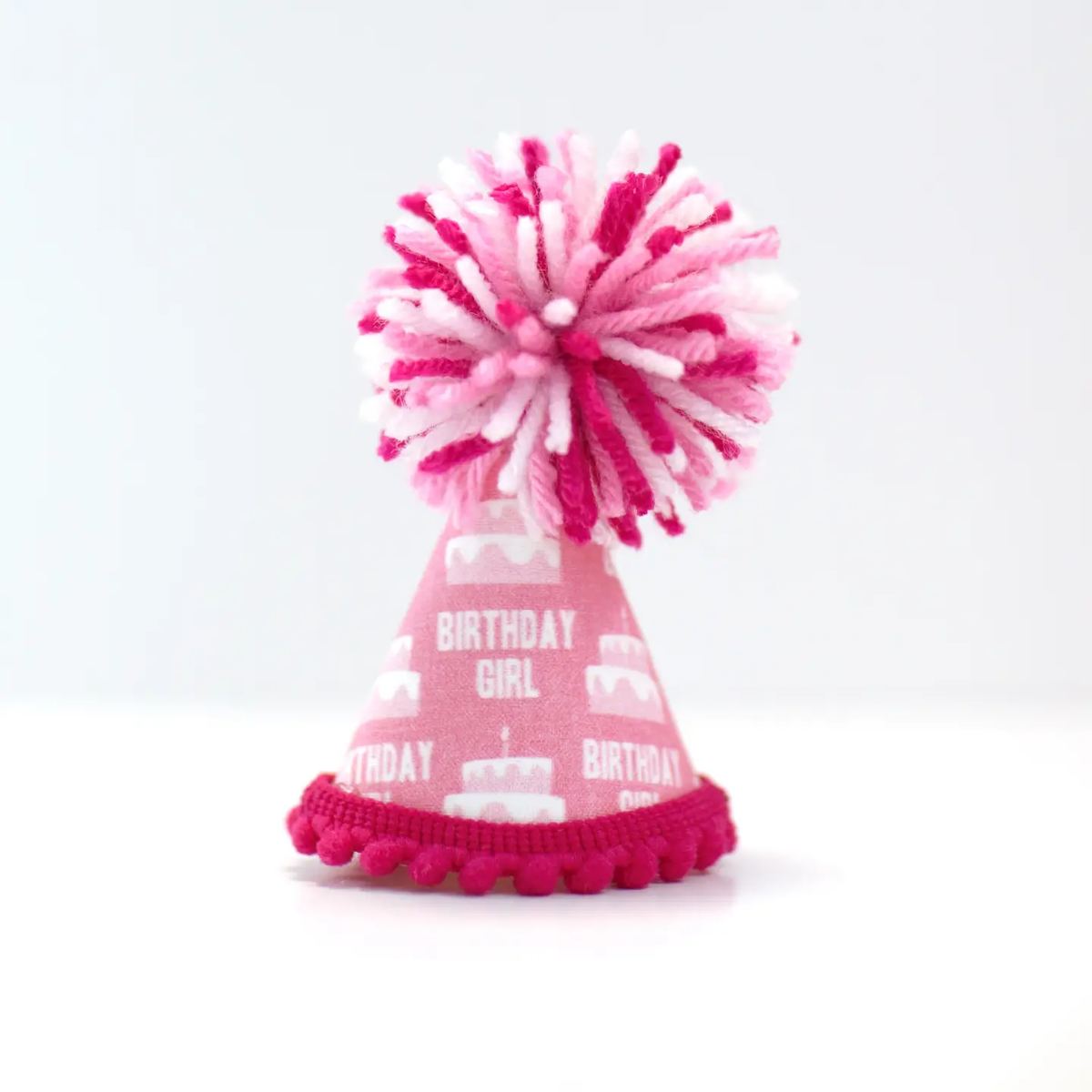 Pink cone party hat with pink pom-pom and “Birthday Girl” print