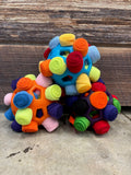 Assorted-color plush snuffle balls with fabric nubs and cutout openings