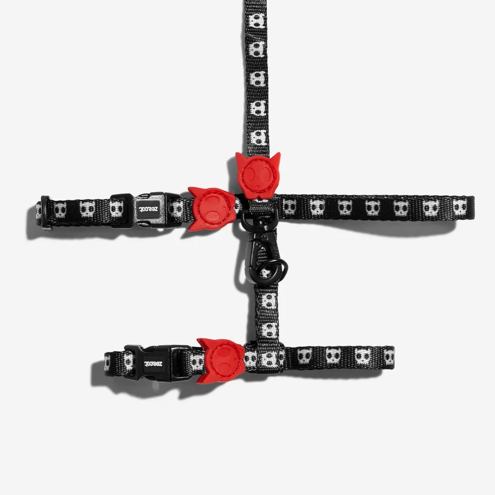 Cat harness with black skull pattern and red paw accents, with adjustable straps.